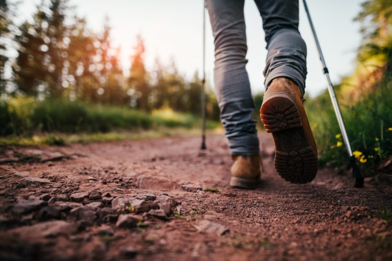 A hiker walks on a mountain trail.