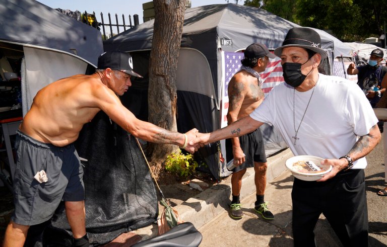 Actor Danny Trejo, right, shakes hands with Gulf War veteran Joseph Fields at his tent outside the Veterans Administration Medical Center campus, on Thursday, Sept. 24, 2020, in Los Angeles.
