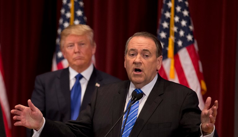 Republican presidential candidates Rick Santorum, left, and Donald Trump, center, listen to Mike Huckabee during a campaign event on the campus of Drake University Thursday, Jan. 28, 2016, in Des Moines, Iowa.