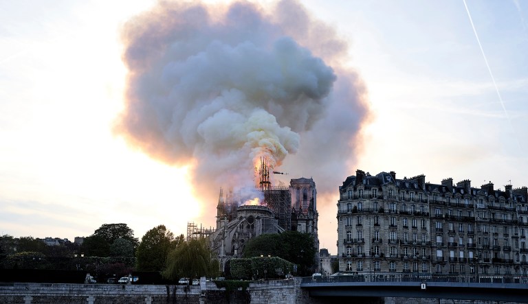 Flames and smoke rise as the spire on Notre Dame cathedral collapses in Paris, Monday, April 15, 2019. Massive plumes of yellow brown smoke is filling the air above Notre Dame Cathedral and ash is falling on tourists and others around the island that marks the center of Paris.