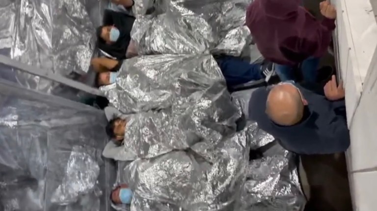 Men sleep side by side in a tent.