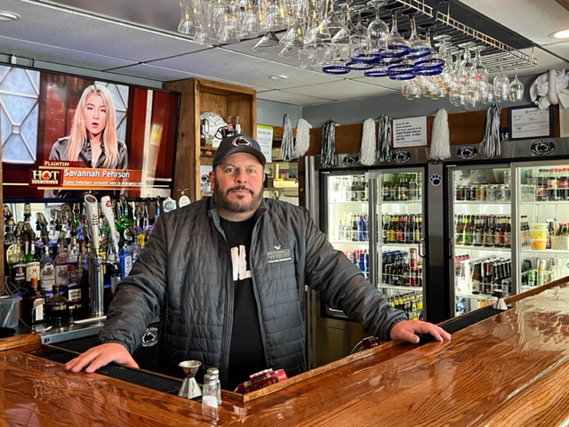 Pat Romano stands at the bar inside of 