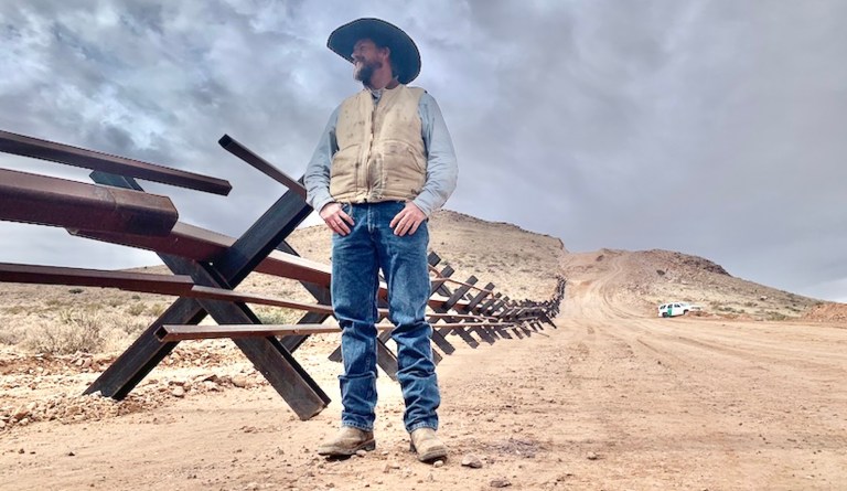 Cattle rancher Russell Johnson stands on his property, which runs along the U.S.-Mexico border.