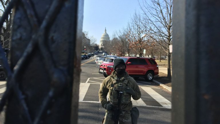 A National Guard member is visible through a heavily-fortified perimeter fence surrounding the U.S. Capitol March 4, 2021.