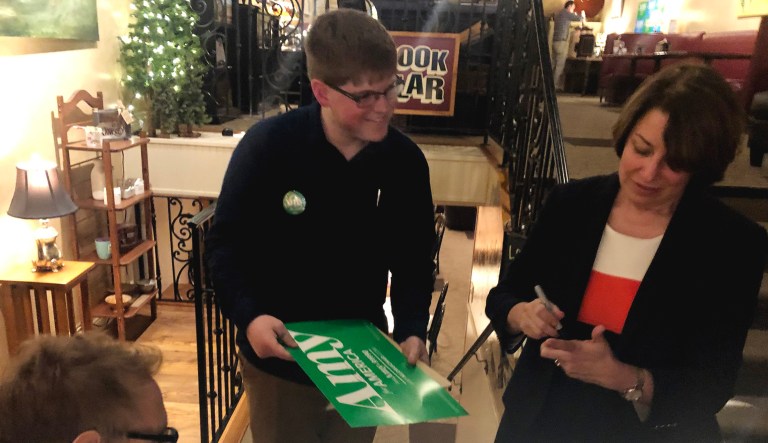 Amy Klobuchar signs a poster during a campaign stop.