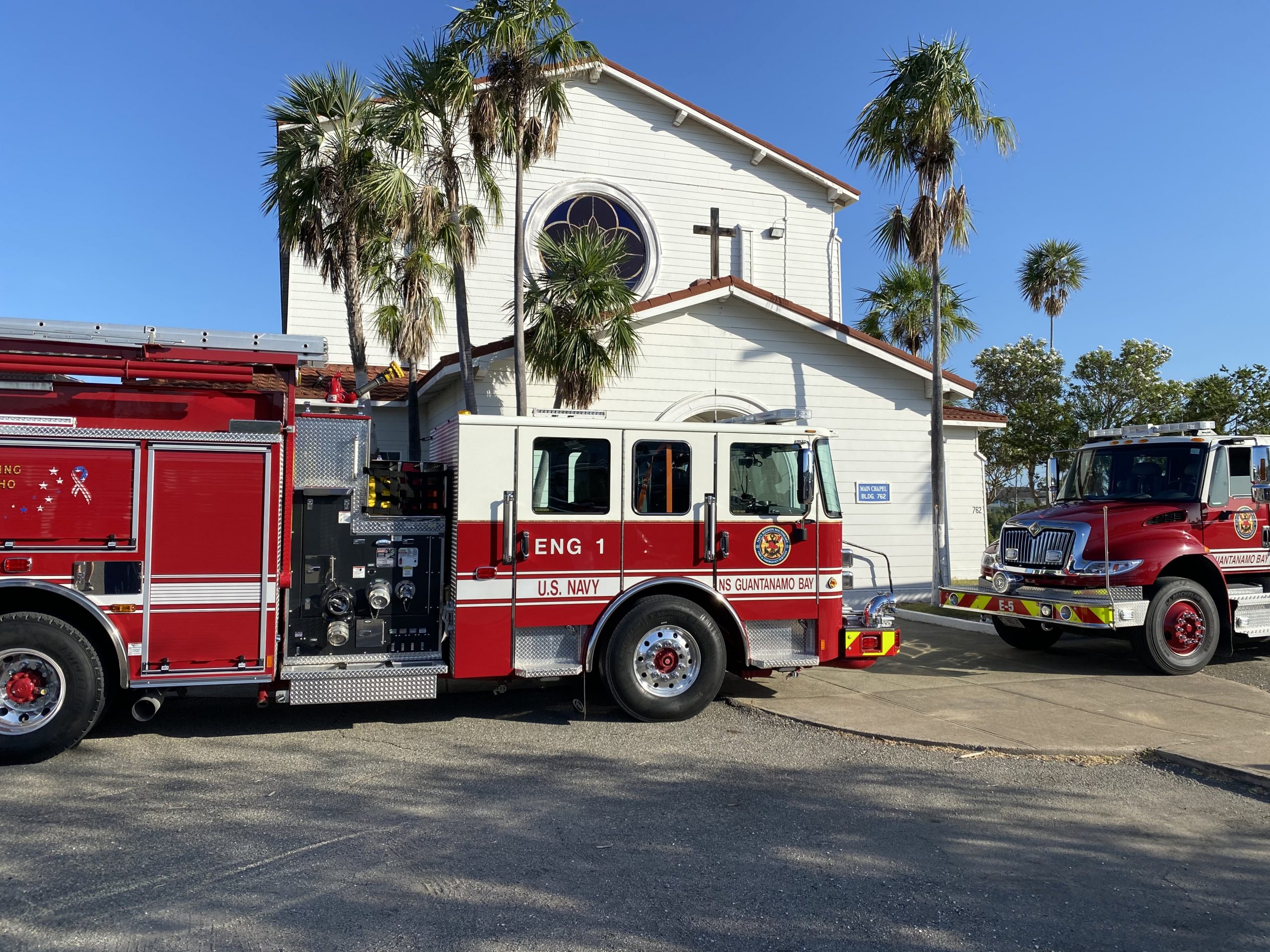Two fire trucks are stationed in front of a chapel in Guantanamo Bay, Cuba.