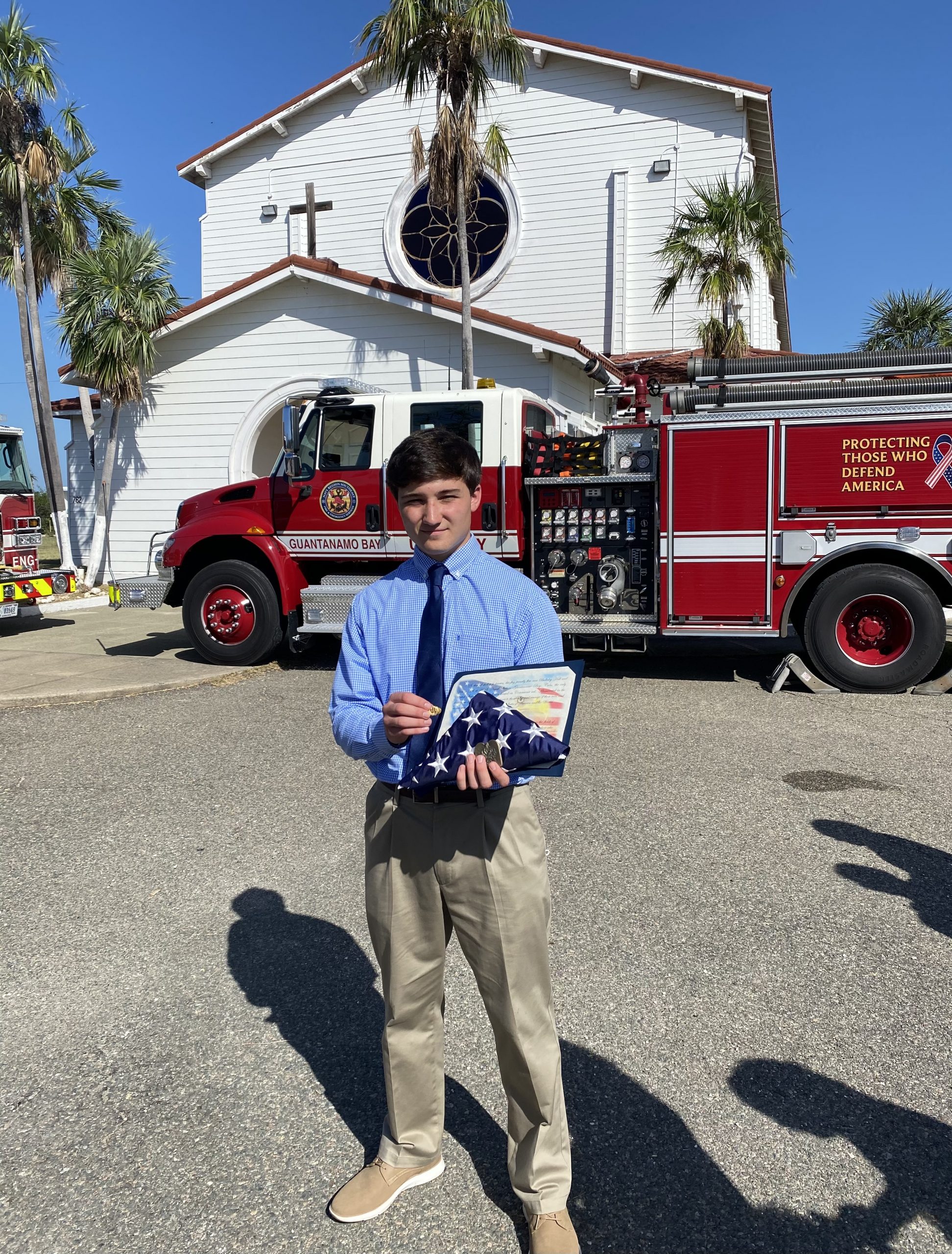 Liam Canavan holds a folded American flag in front of the chapel at Guantanamo Bay, Cuba, after a 9/11 memorial was held Saturday on the 20th anniversary of the attacks.