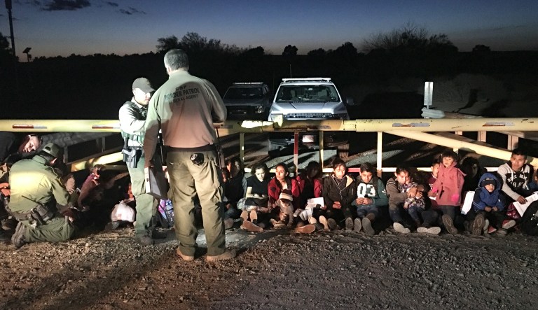 Border Patrol officers are seen with people who came across the U.S.-Mexico border illegally.