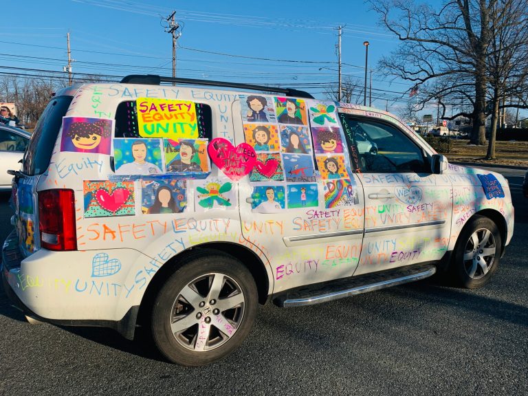 An art teacher displays her student's artwork at a February 23, 2021, car rally against the school reopening plan in Montgomery County, Maryland.