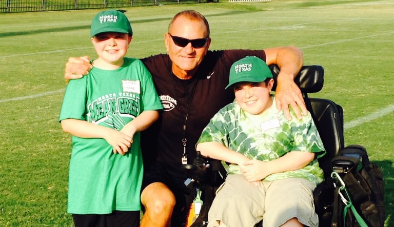 Corbin Fanning, then-North Texas coach Dan McCarney, and Michael Hope. The two boys, stricken with Duchenne muscular dystrophy, were adopted by the Mean Green as team members eight years ago.