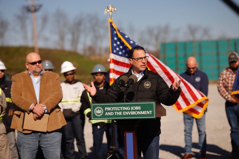 Pennsylvania Gov. Josh Shapiro and CNX CEO Nick Deluliis flanked by the business agent for the Boilermakers local Shawn Steffee and the president of the Pennsylvania Environmental Council Davitt Woodwell add a natural gas well pad in Washington county Pennsylvania where they announced their historic partnership.