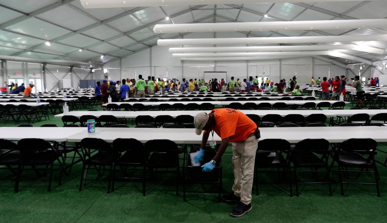 In this July 9, 2019, photo, a staff member cleans in a dinning hall at the U.S. government's newest holding center for migrant children in Carrizo Springs, Texas. The government said the holding center will give it much-needed capacity to take in more children from the Border Patrol.