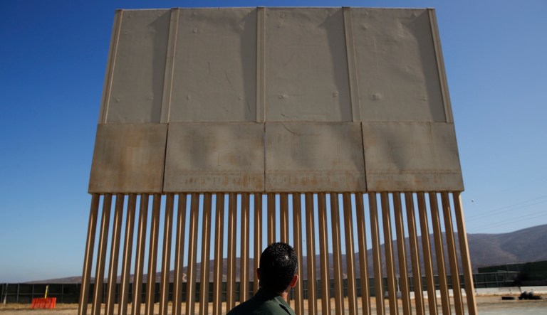A U.S. Border Patrol agent looks at one of the border wall prototypes, Thursday, June 28, 2018, in San Diego.