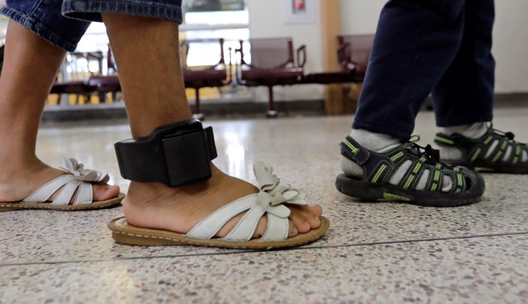 An immigrant woman wears an ankle monitor as she walks through the central bus station after being processed and released by U.S. Customs and Border Protection on June 24, 2018, in McAllen, Texas.