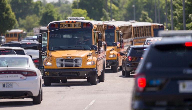 Empty school buses leave after a shooting at Noblesville West Middle School in Noblesville, Ind., on Friday, May 25, 2018. A male student opened fire at the suburban Indianapolis school wounding another student and a teacher before being taken into custody, authorities said.