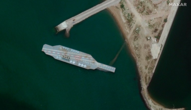 In this Monday, June 8, 2020 satellite photo provided by Maxar Technologies, a fake aircraft carrier is seen off the coast of Bandar Abbas, Iran. As tensions remain high between Iran and the U.S., the Islamic Republic appears to have constructed a new mockup of an aircraft carrier off its southern coast for potential live-fire drills.