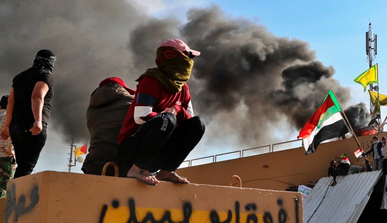 Pro-Iranian militiamen and their supporters set a fire during a sit-in in front of the U.S. embassy in Baghdad, Iraq, Wednesday, Jan. 1, 2020. U.S. troops have fired tear gas to disperse hundreds of pro-Iran militiamen and other protesters who were gathered for a second day outside the American Embassy compound in Baghdad.