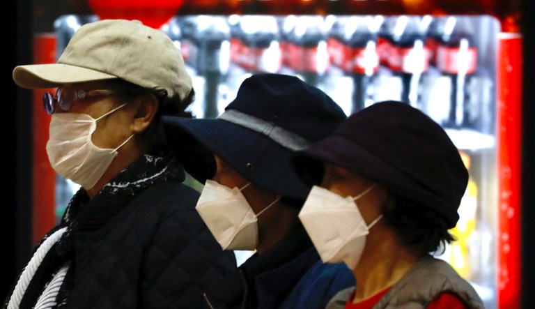Tourists from Korea wearing protective masks walking with their belongings while waiting for a flight back to South Korea at the Ben Gurion airport near Tel Aviv, Israel, Monday, Feb. 24, 2020.