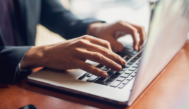 Close up of hands on a keyboard.
