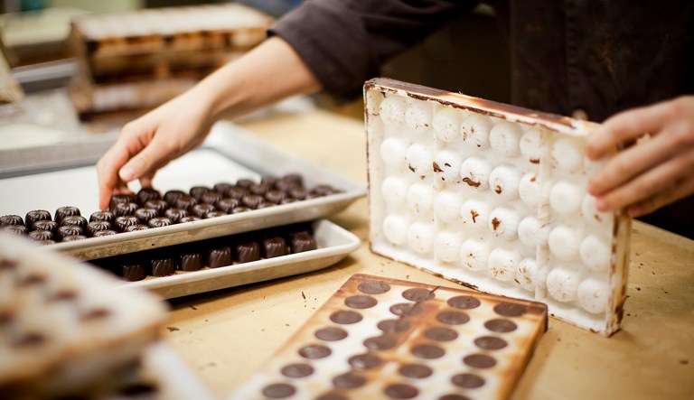 Pastry chef unmolding artisanal stuffed chocolate