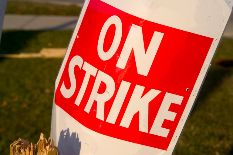 An "On Strike" placard sits on a post.