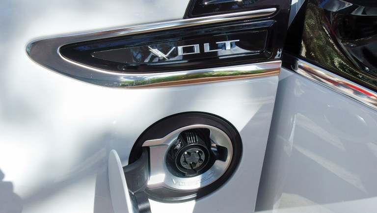 Partial view of a Chevy Volt electric vehicle on display during a National Plug In Day event.