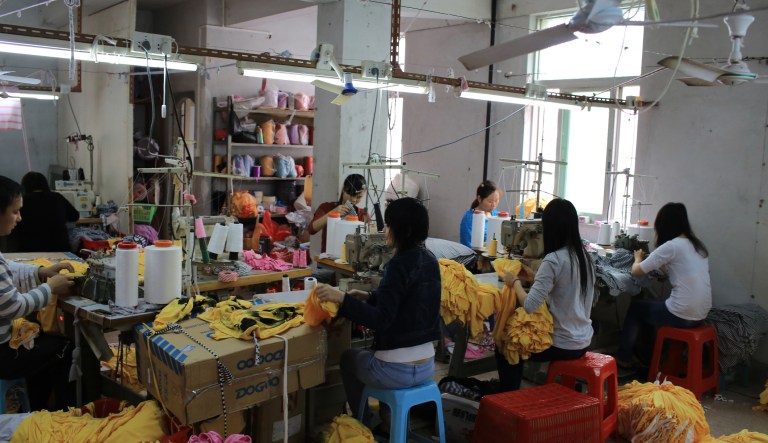 Unidentified labors work in family business clothing workshop in China.