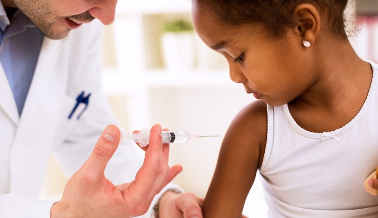A pediatrician vaccinating a young girl.