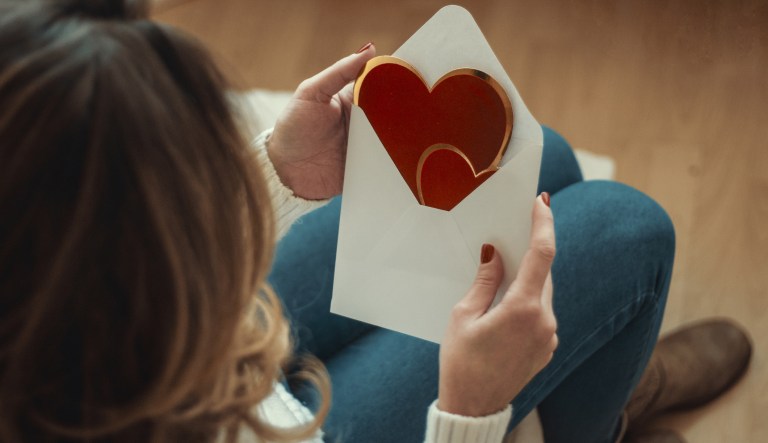 A young woman opens a Valentine's Day card.