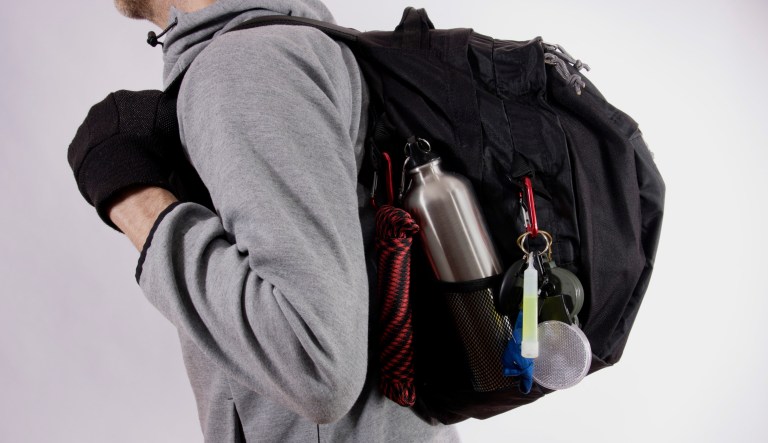 A man wears a bug-out bag.