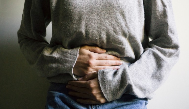 A woman suffers from a stomach ache.