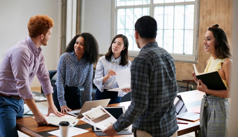 Young adults work around a table.