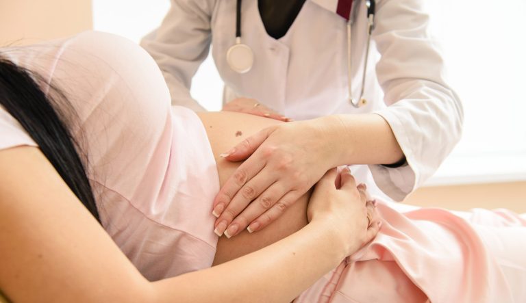 Close-up hand check of pregnancy in hospital.