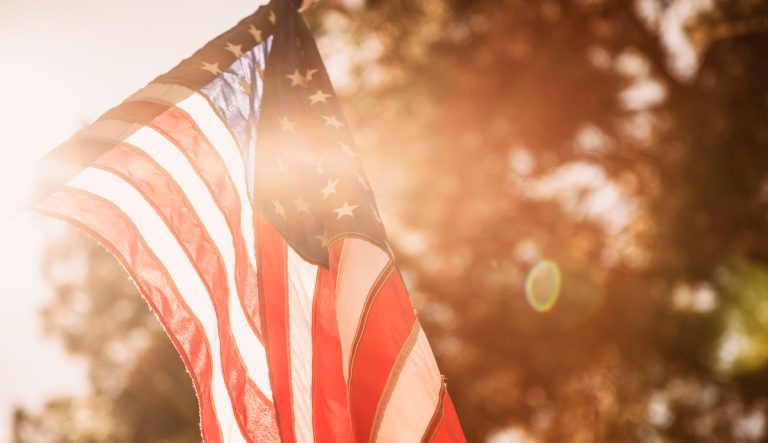 American flag blowing in the breeze on a spring or summer day with lens flare. 