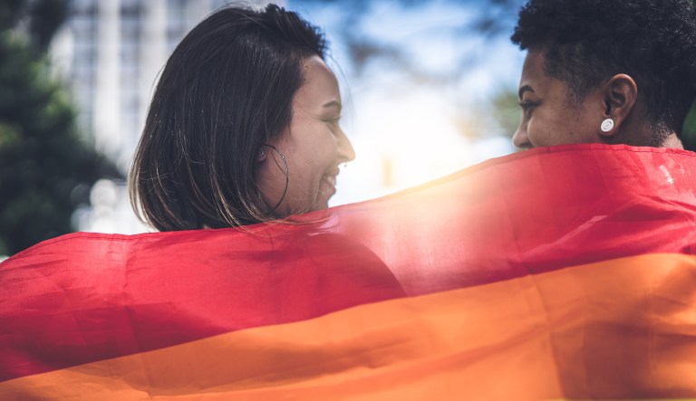 Lesbian couple with rainbow flag.