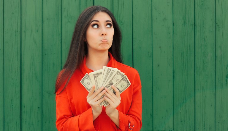 Disappointed woman counts the bills for taxes.