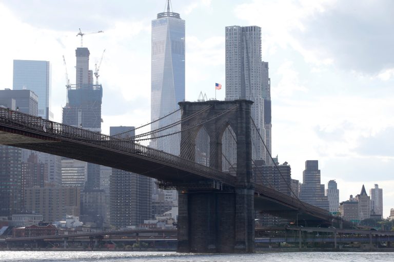 In this June 30, 2016 file photo, the Brooklyn Bridge spans the East River from Brooklyn into Manhattan, as seen from Brooklyn Bridge Park, in New York.  A federal judge has rejected an effort by the Department of Justice to strip a terrorist of U.S. citizenship. Pakistani-born Iyman Faris is a former Ohio truck driver and is serving the last years of a 20-year sentence imposed in 2003 for his guilty plea to plotting with al-Qaida to destroy New York's Brooklyn Bridge. The Department of Justice argues Faris entered the U.S. using someone else's passport, but his Chicago lawyer says his plea agreement never included the possibility of deportation.