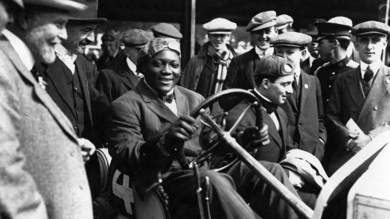 In this photo from the early 1900s, Jack Johnson, the first black world heavyweight champion, sits inside a car.