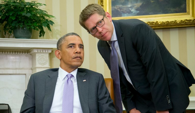 White House Press Secretary Jay Carney talks to President Barack Obama in the Oval Office of the White House in Washington, Thursday, June 12, 2014, during a meeting with Australian Prime MinisterTony Abbott.