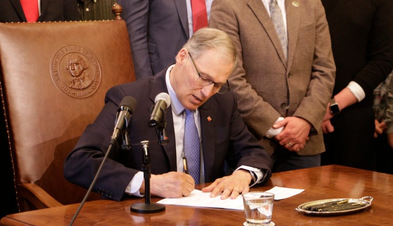 Gov. Jay Inslee signs a bill banning licensed therapists from trying to change a minor's sexual orientation, on Wednesday, March 28, 2018, in Olympia, Wash. Washington joins 10 other states, including California and Oregon, plus the District of Columbia that have laws or regulations banning conversion therapy for LGBT minors.