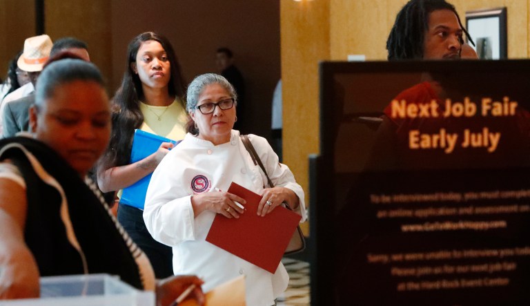 In this Tuesday, June 4, 2019 photo, job applicants line up at the Seminole Hard Rock Hotel & Casino Hollywood during a job fair in Hollywood, Fla.