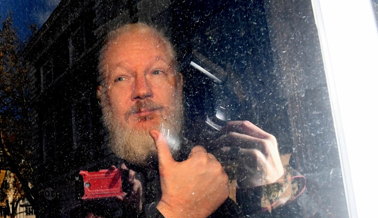 Julian Assange gestures as he arrives at Westminster Magistrates' Court in London, after the WikiLeaks founder was arrested by officers from the Metropolitan Police and taken into custody Thursday April 11, 2019. Police in London arrested WikiLeaks founder Assange at the Ecuadorean embassy Thursday, April 11, 2019 for failing to surrender to the court in 2012, shortly after the South American nation revoked his asylum.