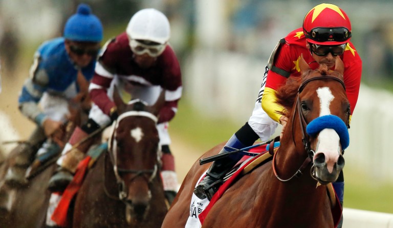 Justify, with jockey Mike Smith up, leads the pack as it approaches the first turn during the 150th running of the Belmont Stakes horse race, Saturday, June 9, 2018, in Elmont, N.Y.