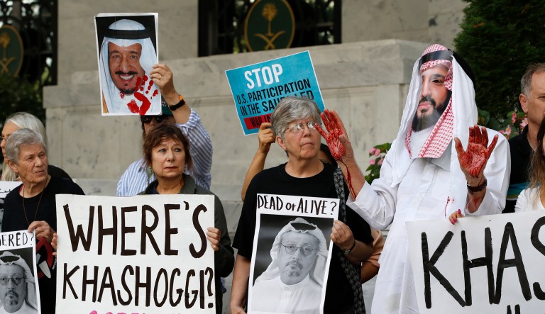 People hold signs at the Embassy of Saudi Arabia during protest about the disappearance of Saudi journalist Jamal Khashoggi, Wednesday, Oct. 10, 2018, in Washington. David Barrows, right, with Code Pink, wears a mask of Saudi Arabia Crown Prince Mohammed bin Salman.