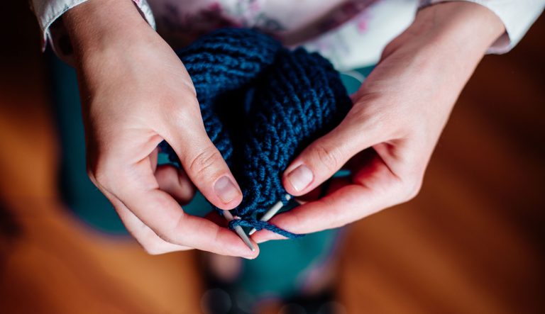A woman knits wool clothes.