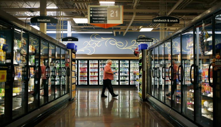 A customer walks past the frozen food aisle inside a Kroger Co. grocery store in Louisville, Kentucky.