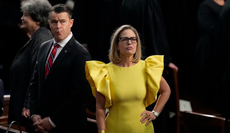 Sen. Kyrsten Sinema, right, and Sen. Todd Young, left, stand in the House Chamber before President Joe Biden arrives and delivers the State of the Union address to a joint session of Congress at the Capitol, Tuesday, Feb. 7, 2023, in Washington.
