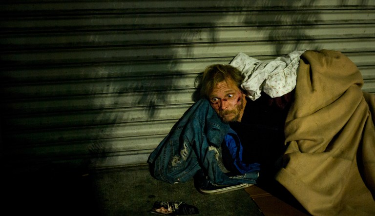 Bearing cuts all over his face, a homeless drug addict, who said his name is April Jane, aimlessly stares into space on a sidewalk in the Skid Row area of downtown Los Angeles, Thursday, Nov. 2, 2017. No one shares the same story how they ended up in the center of poverty and despair. The streets are ruled by drugs day and night. Help exists, but too many turn to drugs to cope with their problems.