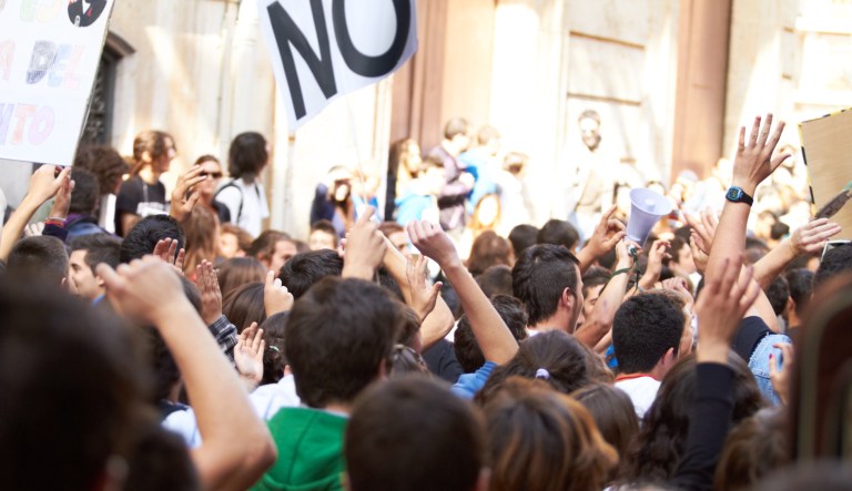 Rearview shot of a crowd protesting outside a public building
