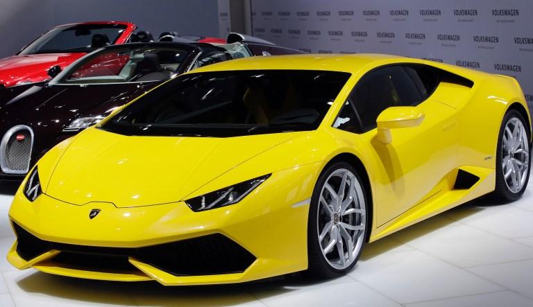 A Lamborghini Huracan LP 610-4, front, a Bugatti Veyron 16.4, center, and a Bugatti GTV8S Convertible, rear are pictured during the annual press conference of the Volkswagen AG in Berlin, Germany, Thursday, March 13, 2014. (AP Photo/Michael Sohn)